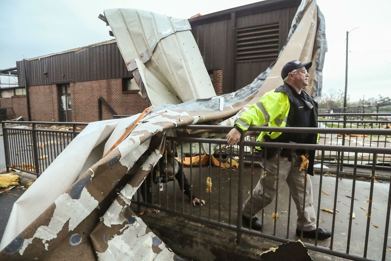 An officer moves past debris at Newnan High School in Georgia.