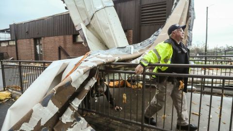 An officer moves past debris at Newnan High School in Georgia.