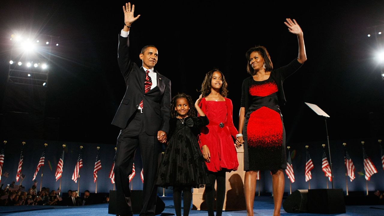 CHICAGO - NOVEMBER 04:  U.S. President elect Barack Obama stands on stage along with his wife Michelle and daughters Malia (red dress) and Sasha  (black dress) during an election night gathering in Grant Park on November 4, 2008 in Chicago, Illinois. Obama defeated Republican nominee Sen. John McCain (R-AZ) by a wide margin in the election to become the first African-American U.S. President elect.  (Photo by Joe Raedle/Getty Images)