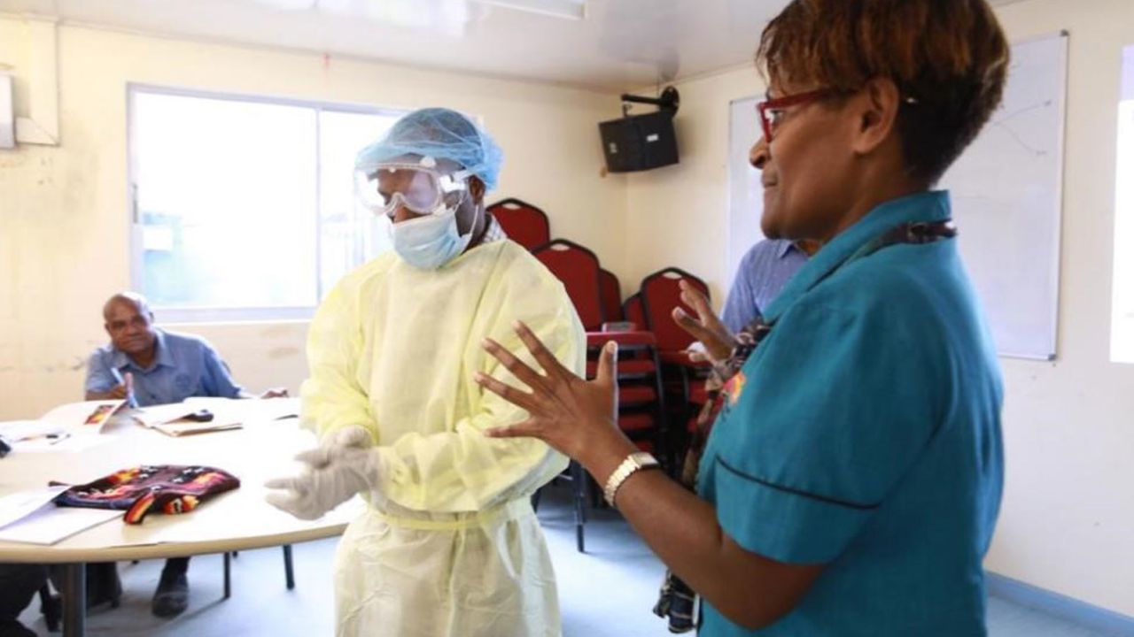 Janlyn Kumbu of PNG's Central Public Health Laboratory trains health workers in Vanimo, West Sepik, on proper PPE procedures.