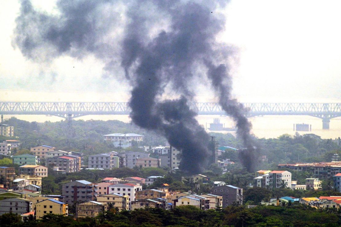 Smoke rises over Thaketa township in Yangon on March 27, 2021, as security forces continue their crackdown on protests against the military coup. 