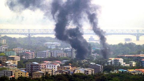 Smoke rises over Thaketa township in Yangon on March 27, 2021, as security forces continue their crackdown on protests against the military coup.