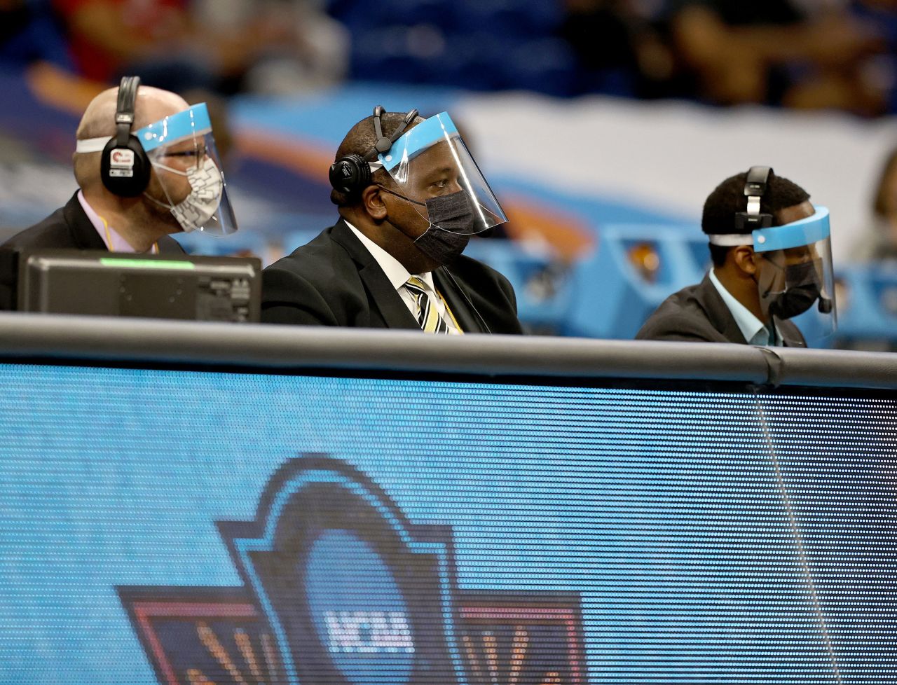 Men wear face shields at the scorer's table during the Indiana-NC State game.
