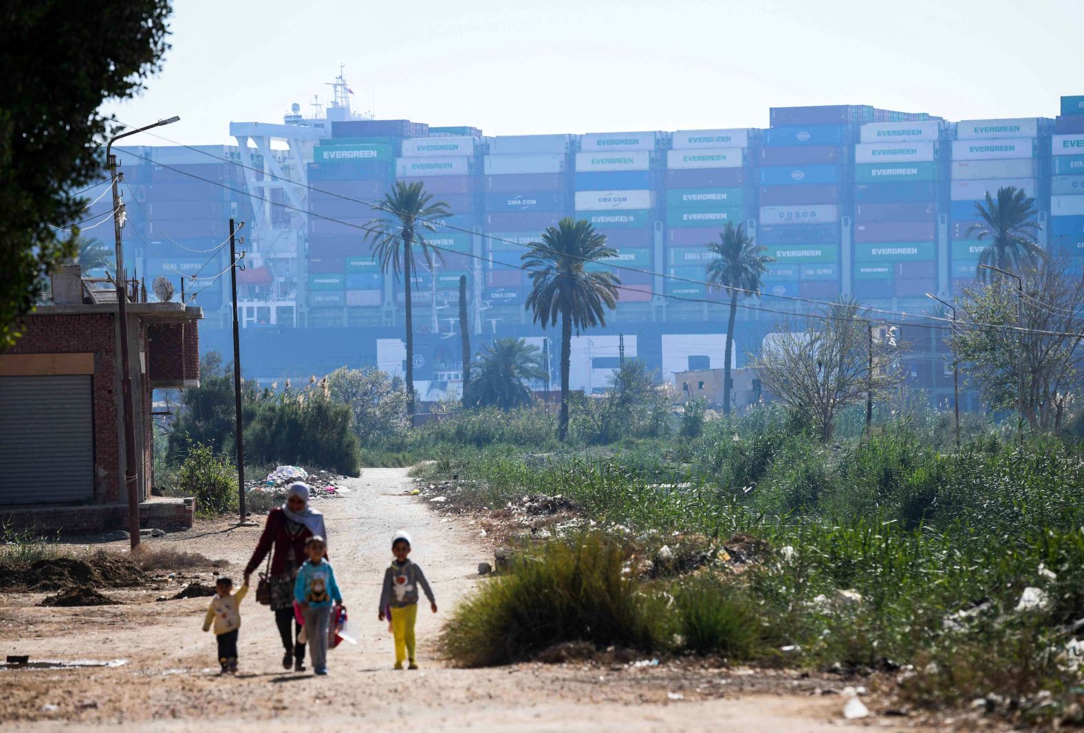 A woman walks with children near the ship on Saturday.