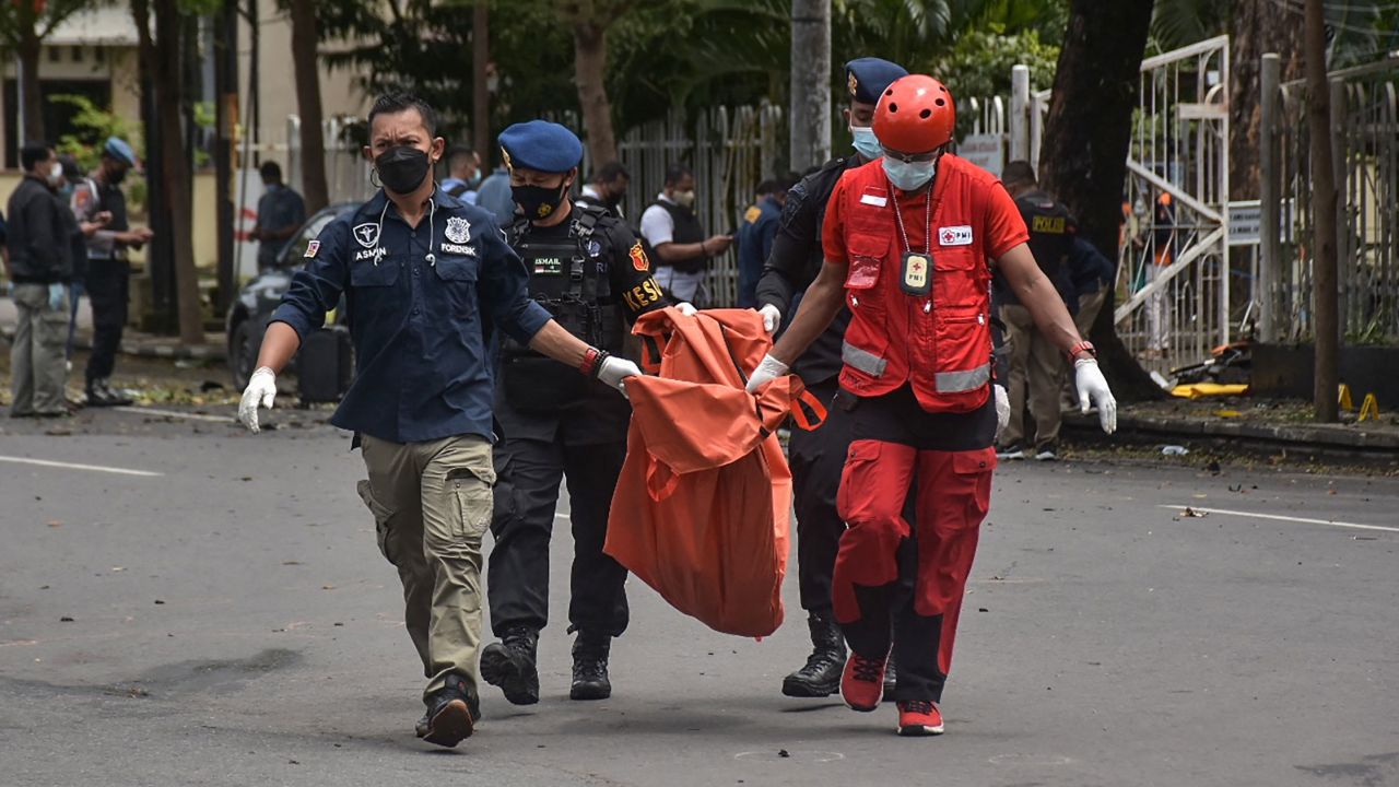 Indonesian police carry the remains of a suspected suicide bomber after an explosion outside a church in Makassar on March 28.
