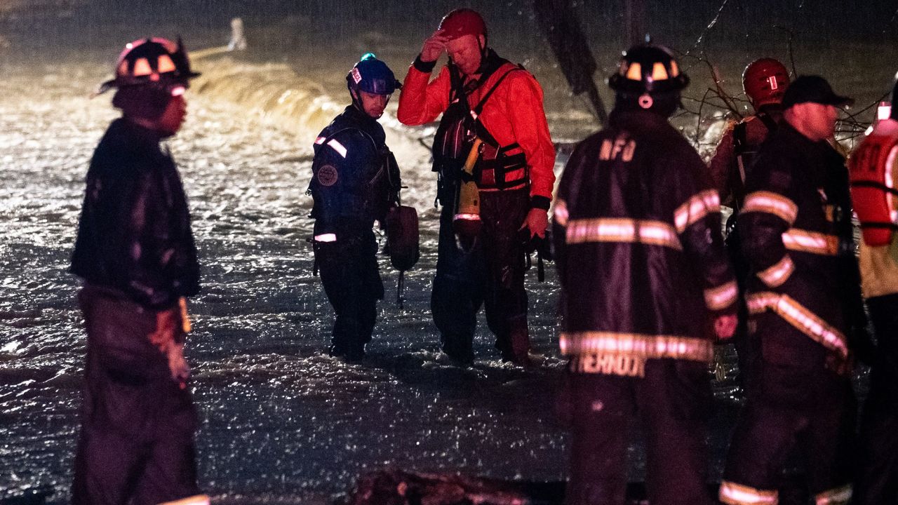 Emergency personnel gather after responding to a call to help people stranded in the water on Antioch Pike in Nashville on Sunday.