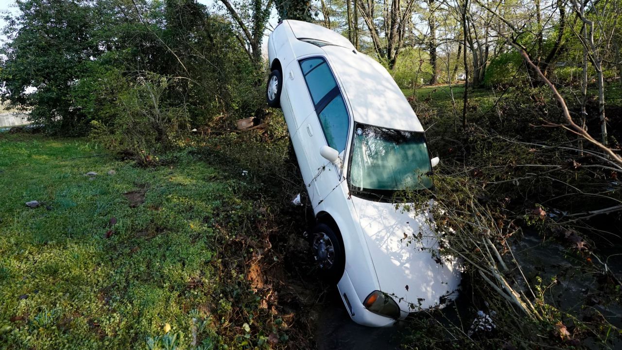 A car carried by floodwaters leans against a tree in Nashville, Tennessee, on Sunday, March 28.