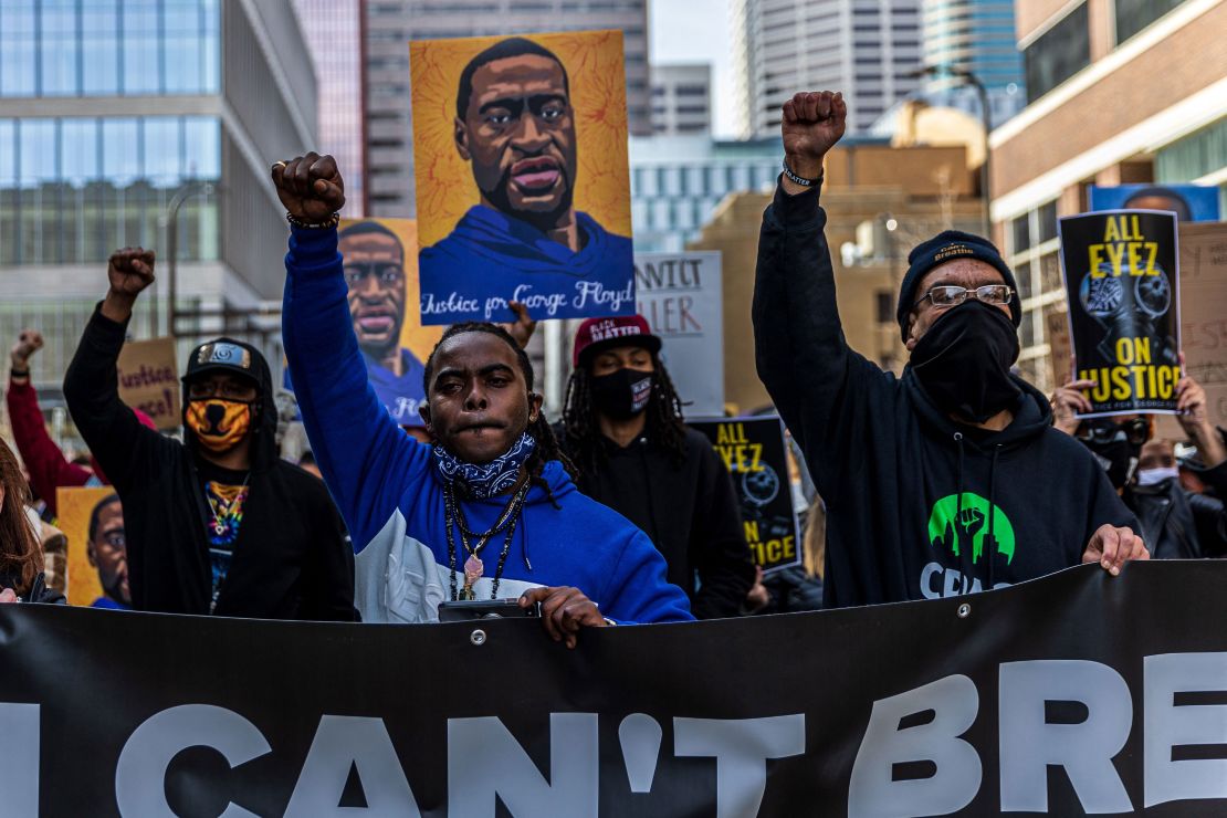 Demonstrators hold signs honoring George Floyd and other victims of racism as they  protest on March 28, 2021 in Minneapolis.