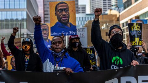 Demonstrators hold signs honoring George Floyd and other victims of racism as they protest on March 28, 2021 in Minneapolis.