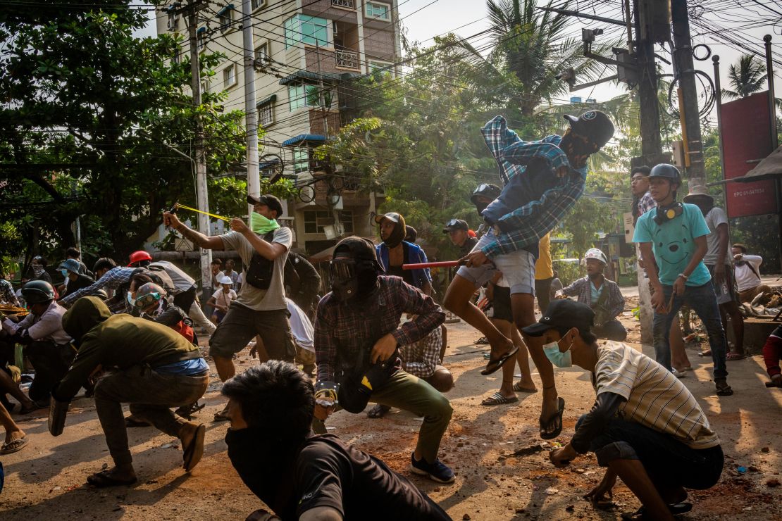 Anti-coup protesters use slingshots and pelt stones towards approaching security forces on March 28 in Yangon, Myanmar. 