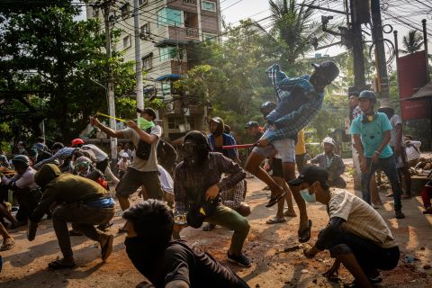 Protesters throw stones and use slingshots as security forces approached in Yangon on March 28.