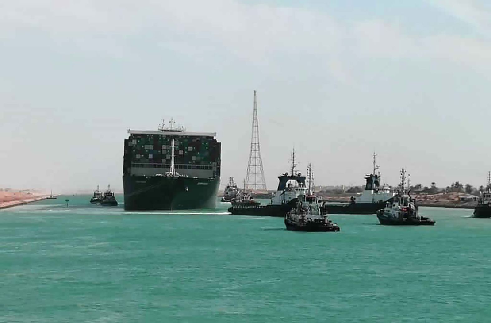 The Ever Given is accompanied by tugboats as it moves through the canal on Monday.