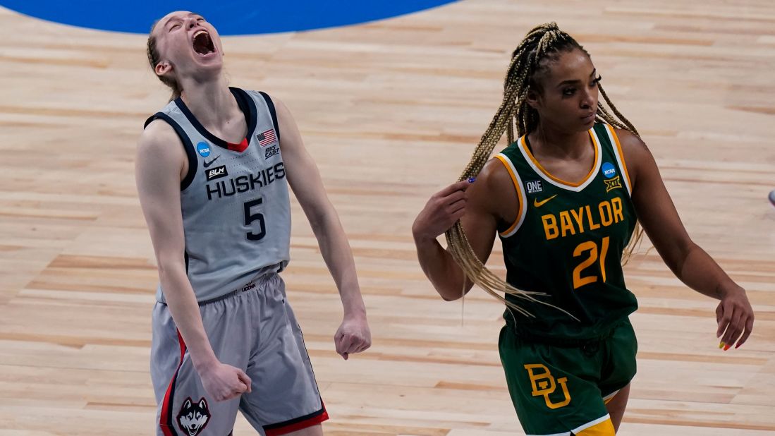 Connecticut guard Paige Bueckers, left, celebrates her team's Final Four berth as Baylor guard DiJonai Carrington walks off the court on Monday. UConn won 69-67 to make the Final Four for the 13th consecutive season.