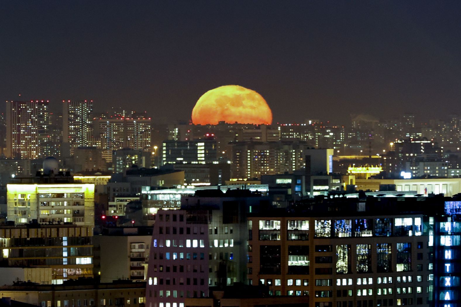 The moon rises over Moscow, Russia.