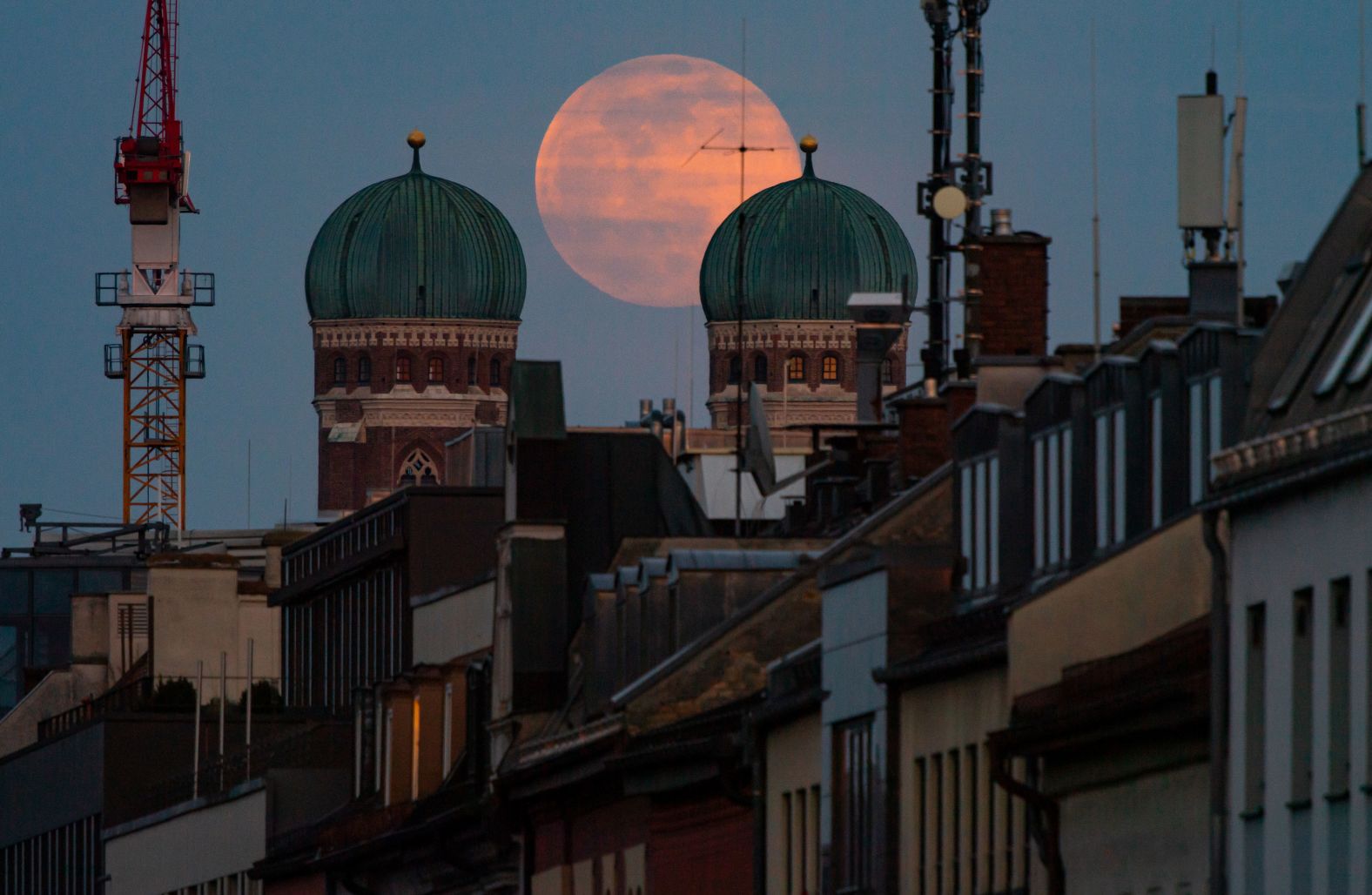 The full moon stands between the twin towers of the Frauenkirche cathedral, in Munich, Germany.