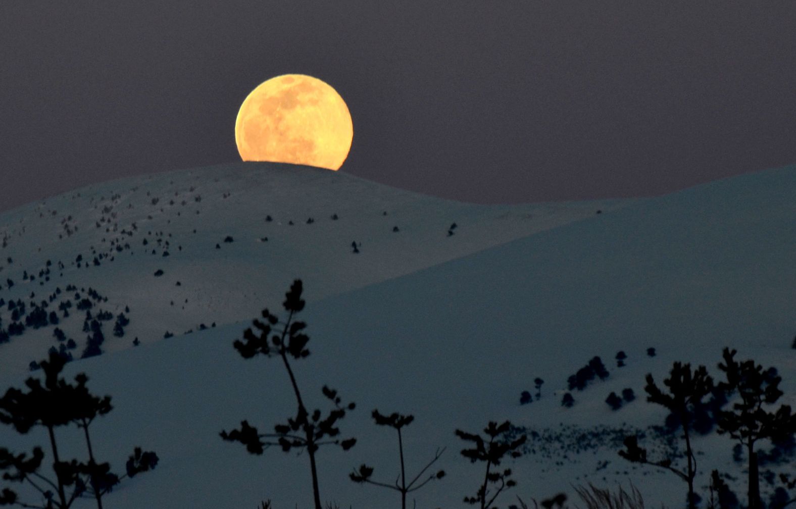 The moon rises over Kars, Turkey.