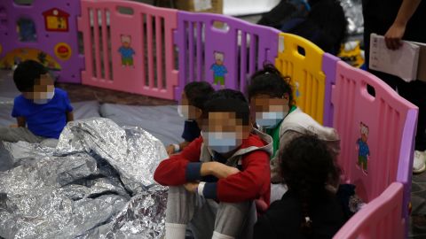 Young unaccompanied migrants, ages 3-9 sit inside a play pen in the Department of Homeland Security holding facility on March 30, 2021 in Donna, Texas. CNN has blurred faces to protect individuals' identities.