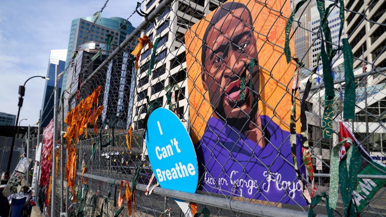 A picture of George Floyd hangs on a fence outside the Hennepin County Government Center, Tuesday, March 30, 2021, in Minneapolis where the trial for former Minneapolis police officer Derek Chauvin continues. Chauvin is charged with murder in the death of Floyd during an arrest last May in Minneapolis. (AP Photo/Jim Mone)