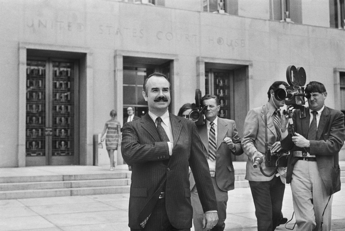Former White House aide G. Gordon Liddy is filmed by journalists as he leaves US District Court, where he pleaded not guilty of breaking into Democratic National Headquarters at the Watergate Hotel.