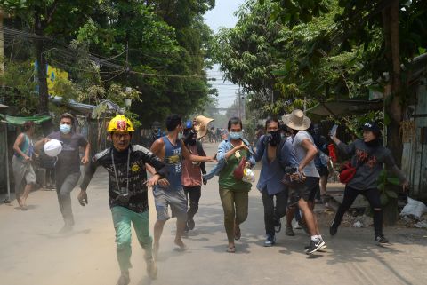 Protesters run to avoid the military in Yangon on March 30.