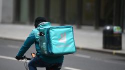 A Deliveroo rider cycles through central London on March 26, 2021. - The meal delivery platform Deliveroo is bracing for strikes and other social actions by disgruntled riders as it gears up for a major London stock listing.  The group has come under fire for employment conditions that have already scared off a couple of large institutional investors (Photo by DANIEL LEAL-OLIVAS / AFP) (Photo by DANIEL LEAL-OLIVAS/AFP via Getty Images)