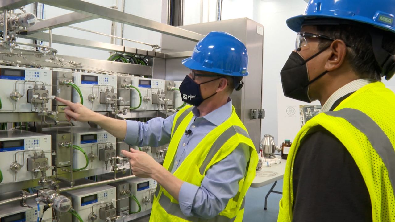 Mike McDermott, Pfizer's president of global supply, left, and CNN's Dr. Sanjay Gupta inside Pfizer's Kalamazoo, Michigan, manufacturing facility.