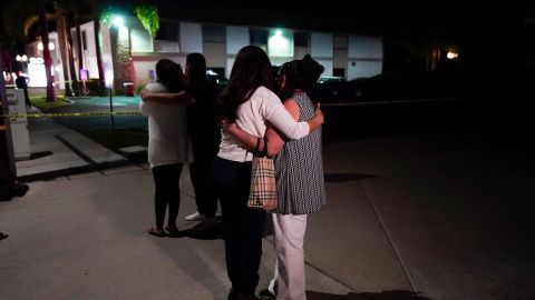 People comfort each other as they stand outside the Orange, California, business complex where the shooting occurred on Wednesday.