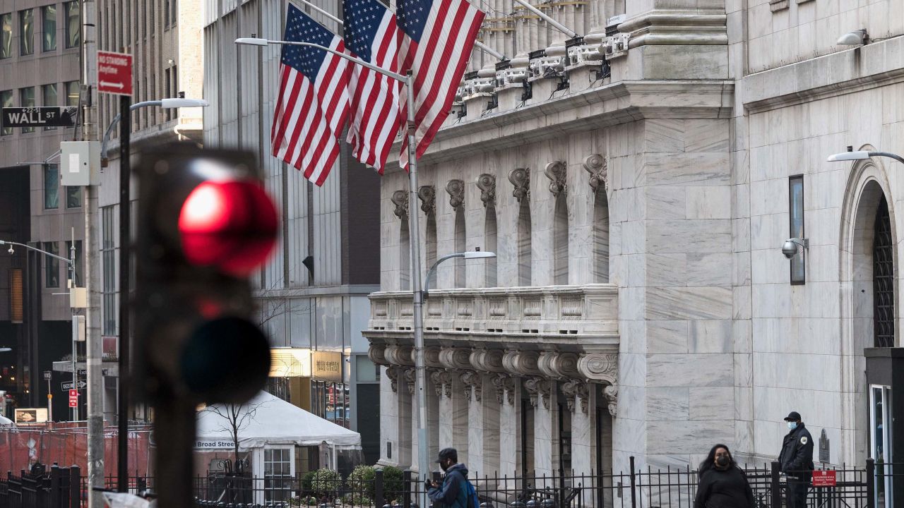 People walk past the New York Stock Exchange (NYSE) at Wall Street on March 23, 2021 in New York City. - Wall Street stocks were under pressure early ahead of congressional testimony from Federal Reserve Chief Jerome Powell as US Treasury bond yields continued to retreat. (Photo by Angela Weiss / AFP) (Photo by ANGELA WEISS/AFP via Getty Images)