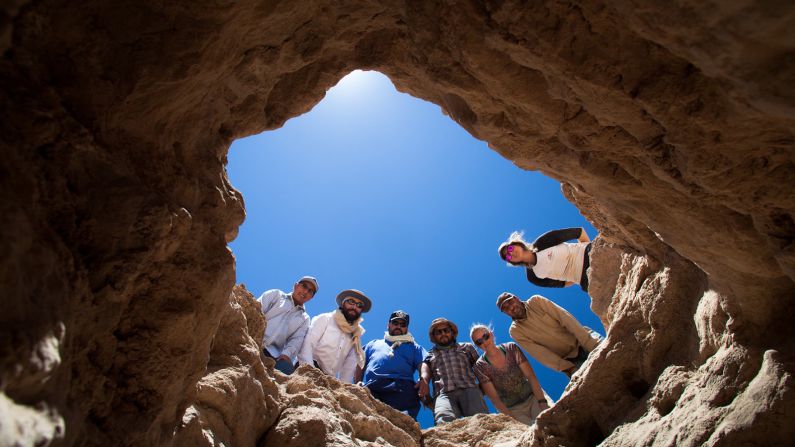 <strong>Drilling for samples: </strong>Members of the 2016 ARADS field science team look down into a more than seven-foot-deep pit from which they acquired samples.