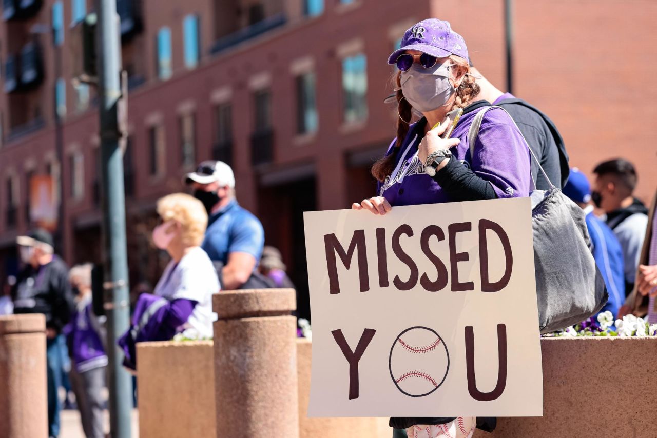 A fan holds a sign outside of Coors Field in Denver.