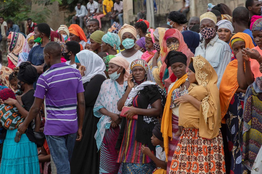 Families wait outside the port of Pemba on April 1 for a boat carrying evacuees from the coasts of Palma to arrive. 