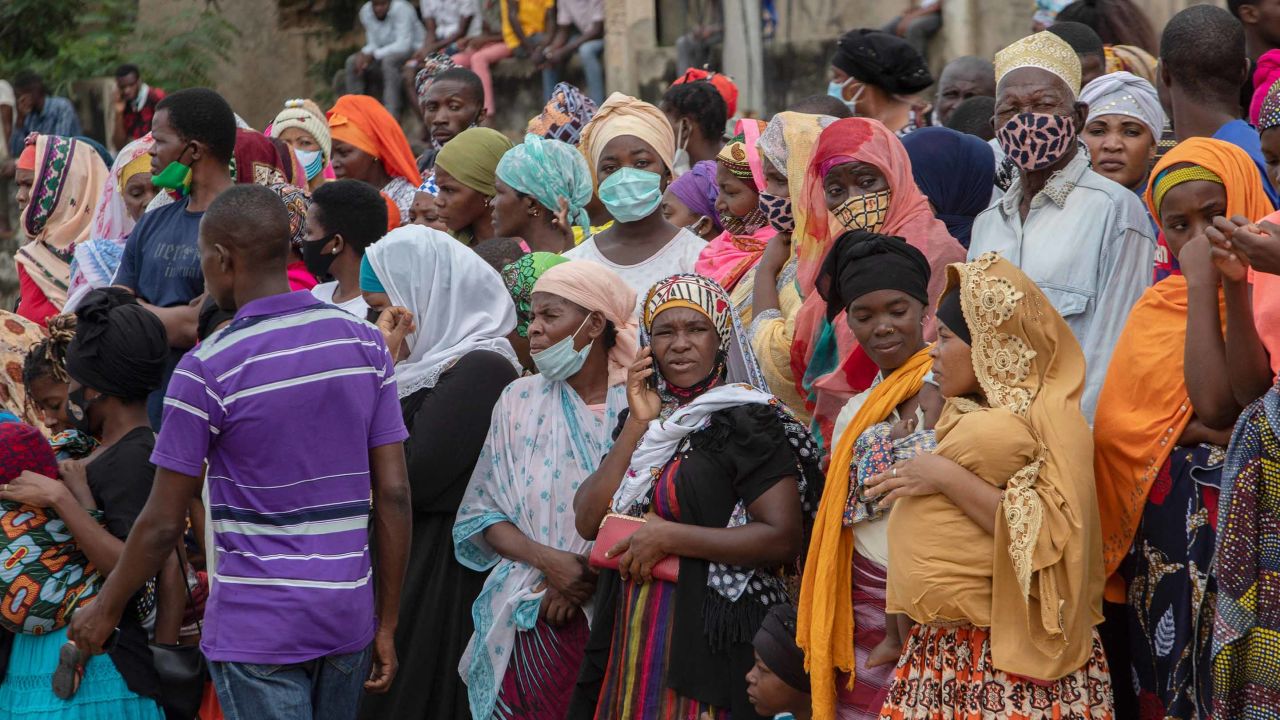 Families wait outside the port of Pemba on April 1 for a boat carrying evacuees from the coasts of Palma to arrive.