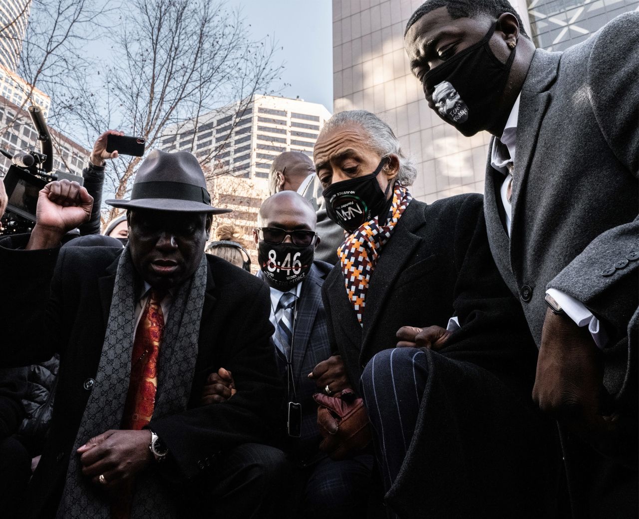 Attorney Ben Crump raises a fist as he takes a knee in Minneapolis with George Floyd's brother Philonise, the Rev. Al Sharpton and Floyd's nephew Brandon Williams on Monday, March 29. <a href="https://www.cnn.com/2021/03/29/us/derek-chauvin-george-floyd-trial-start/index.html" target="_blank">The trial of former police officer Derek Chauvin</a> started on Monday, 10 months after Floyd's death.
