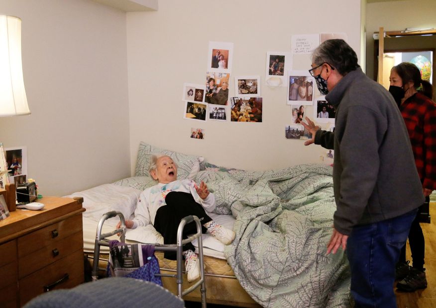 Yoshia Uomoto, 98, reacts as her son Mark Uomoto and niece Gail Yamada surprise her at her assisted-living facility in Seattle on March 30. Because of Covid-19 restrictions, it was their first in-person visit in a year.