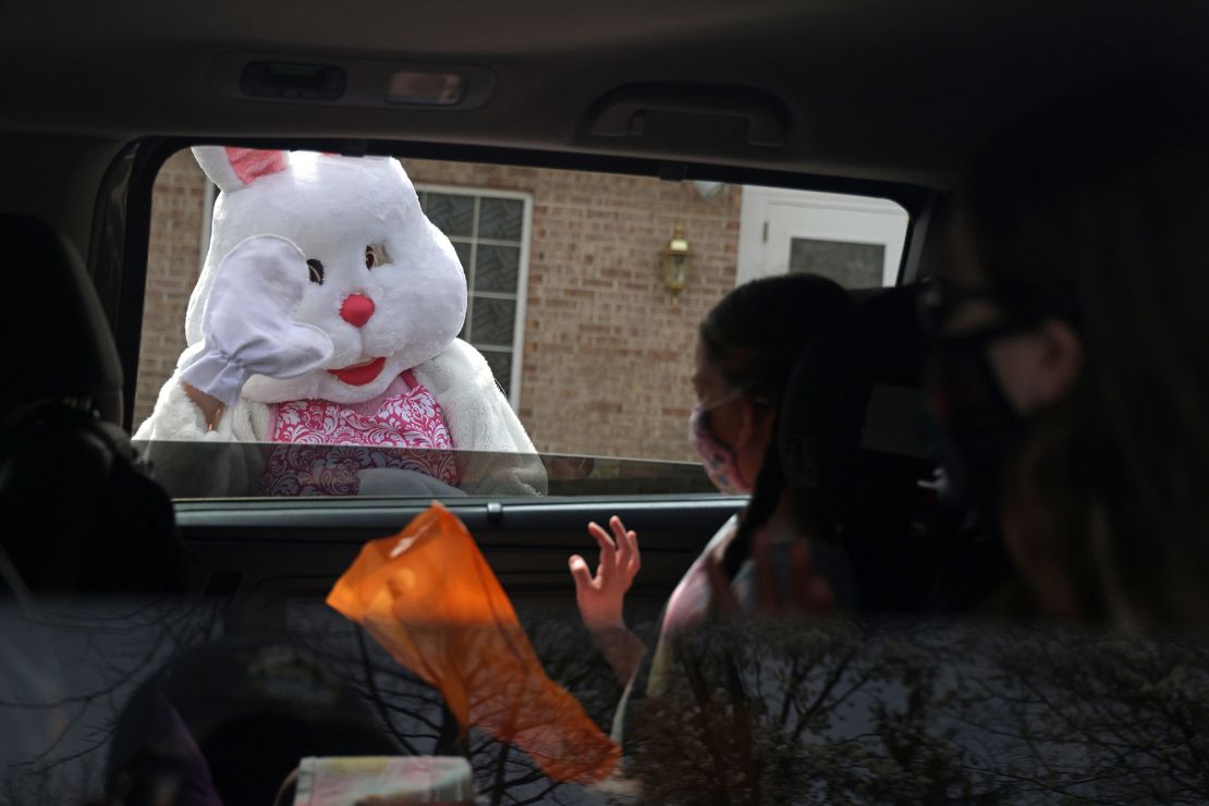 An Easter Bunny greets children during a Bunny Drive-Thru event outside in Alexandria, Virginia.