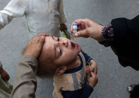 A health worker administers a polio vaccine to a child in Lahore, Pakistan, on Monday, March 29.