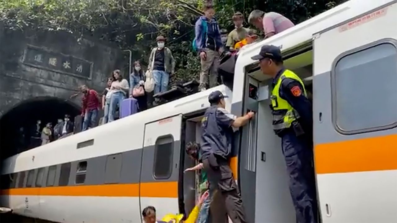Emergency workers assist survivors as they evacuate the derailed train.