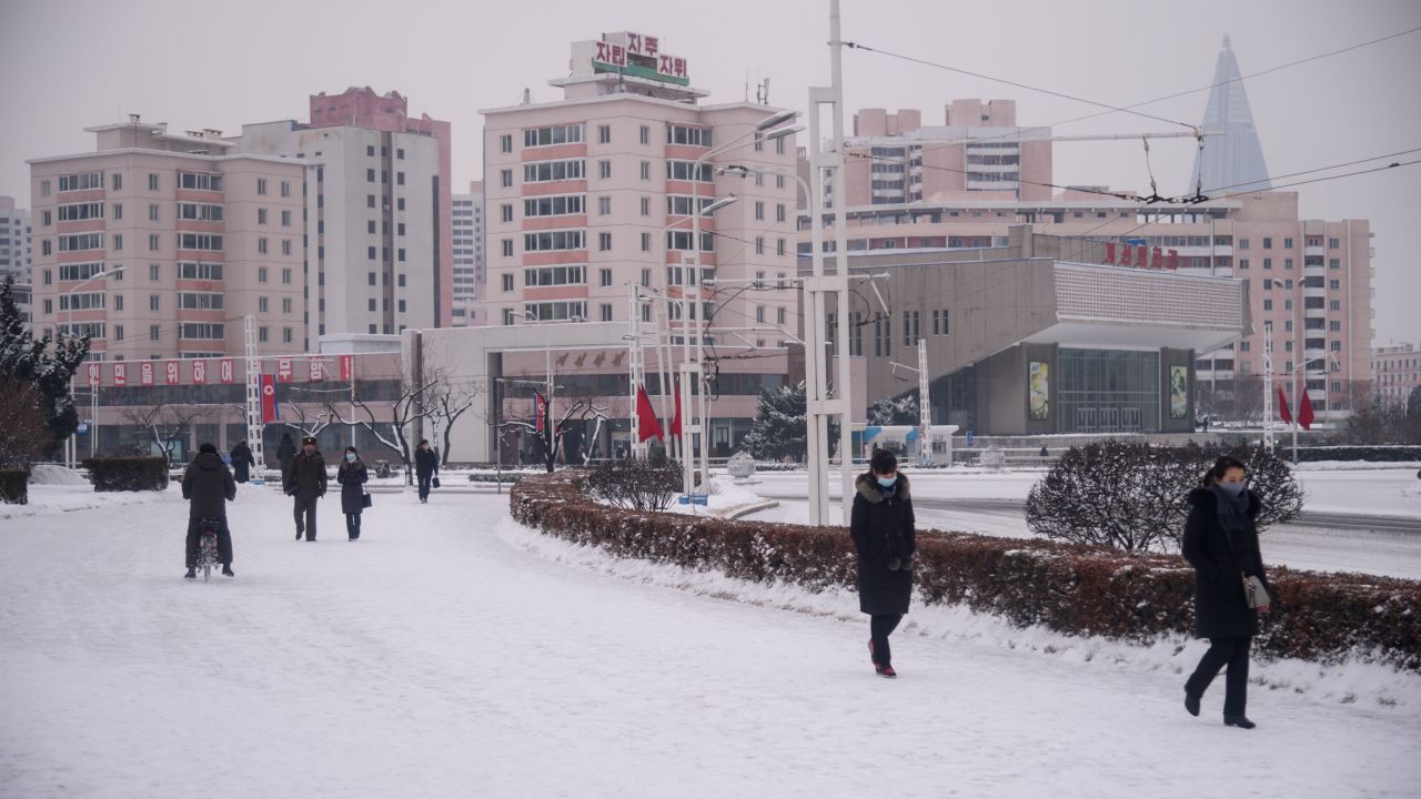 People walk on a snow-covered street near the Arch of Triumph in Pyongyang on January 12.