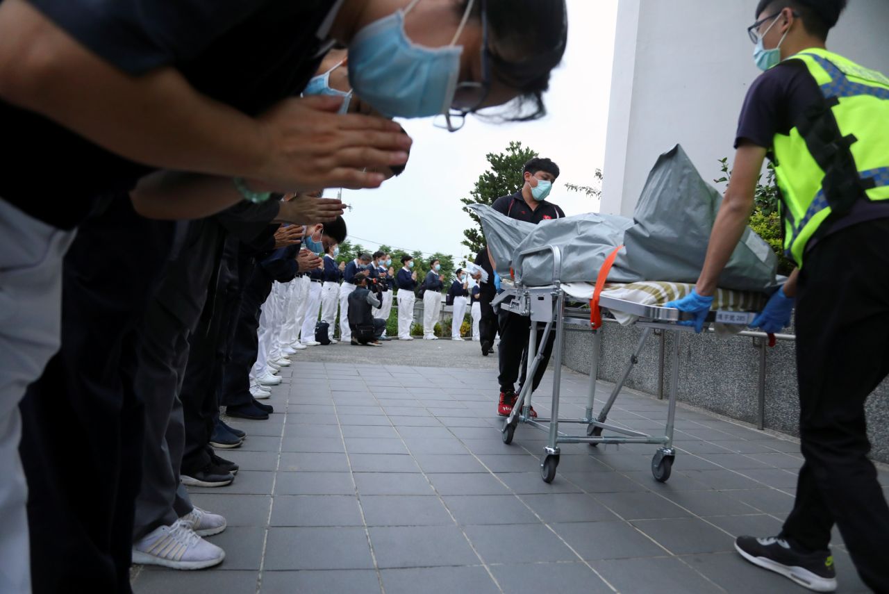 Members of the Tzu Chi Foundation pay their respects as rescuers transfer bodies of crash victims at the Xincheng railway station.