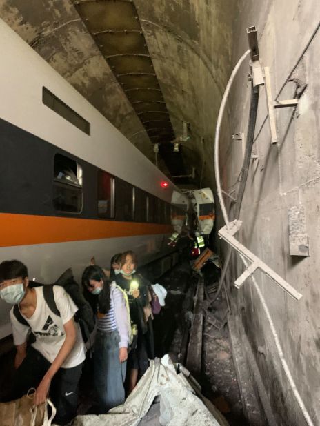 Passengers make their way out of the tunnel where the train derailed.