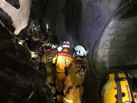 Emergency crews are seen in the tunnel beside the wreckage of the train.