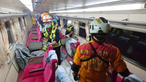 Emergency workers move body bags inside the train.