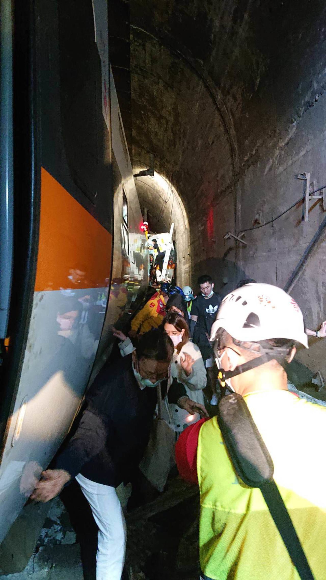 Passengers are seen making their way through the tunnel alongside rescue workers.