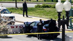 U.S. Capitol Police officers stand near a car that crashed into a barrier on Capitol Hill in Washington, Friday, April 2, 2021. 