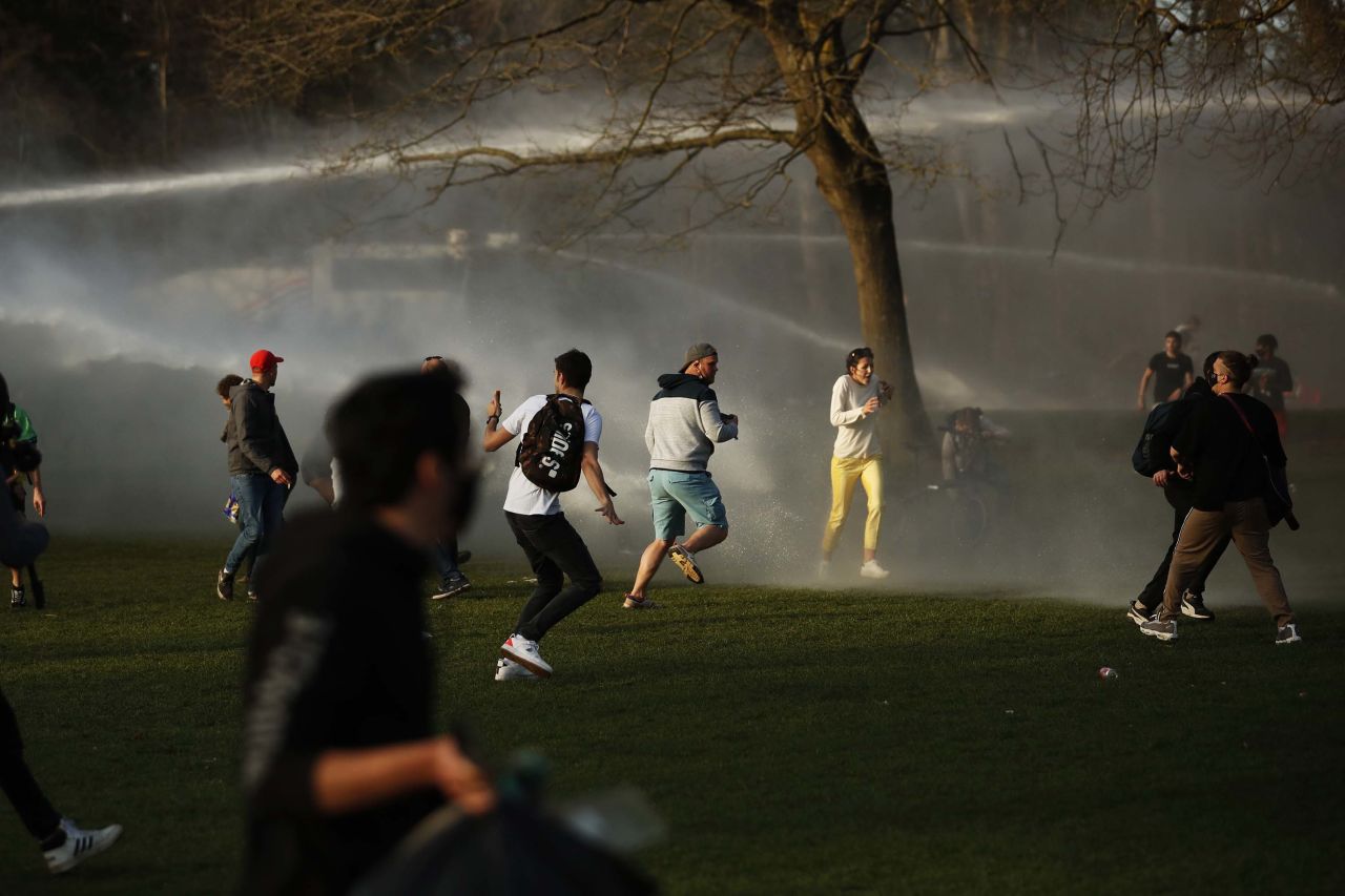 People scatter as police fire water cannons to disperse a crowd at a park in Brussels, Belgium, on April 1. <a href="index.php?page=&url=https%3A%2F%2Fwww.cnn.com%2Fworld%2Flive-news%2Fcoronavirus-pandemic-vaccine-updates-04-02-21%2Fh_bc4daabf47fa48f57503c7de2e9b9aff" target="_blank">Violent clashes broke out</a> between Brussels police and people gathering to attend a fake April Fool's Day festival that violated coronavirus restrictions.