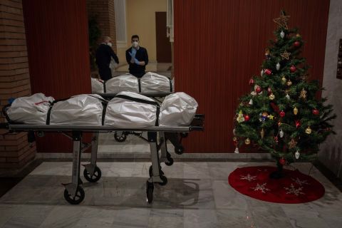 Mortuary workers take off their personal protective equipment after removing the body of a person who allegedly died of Covid-19 in Barcelona, Spain, on December 23.