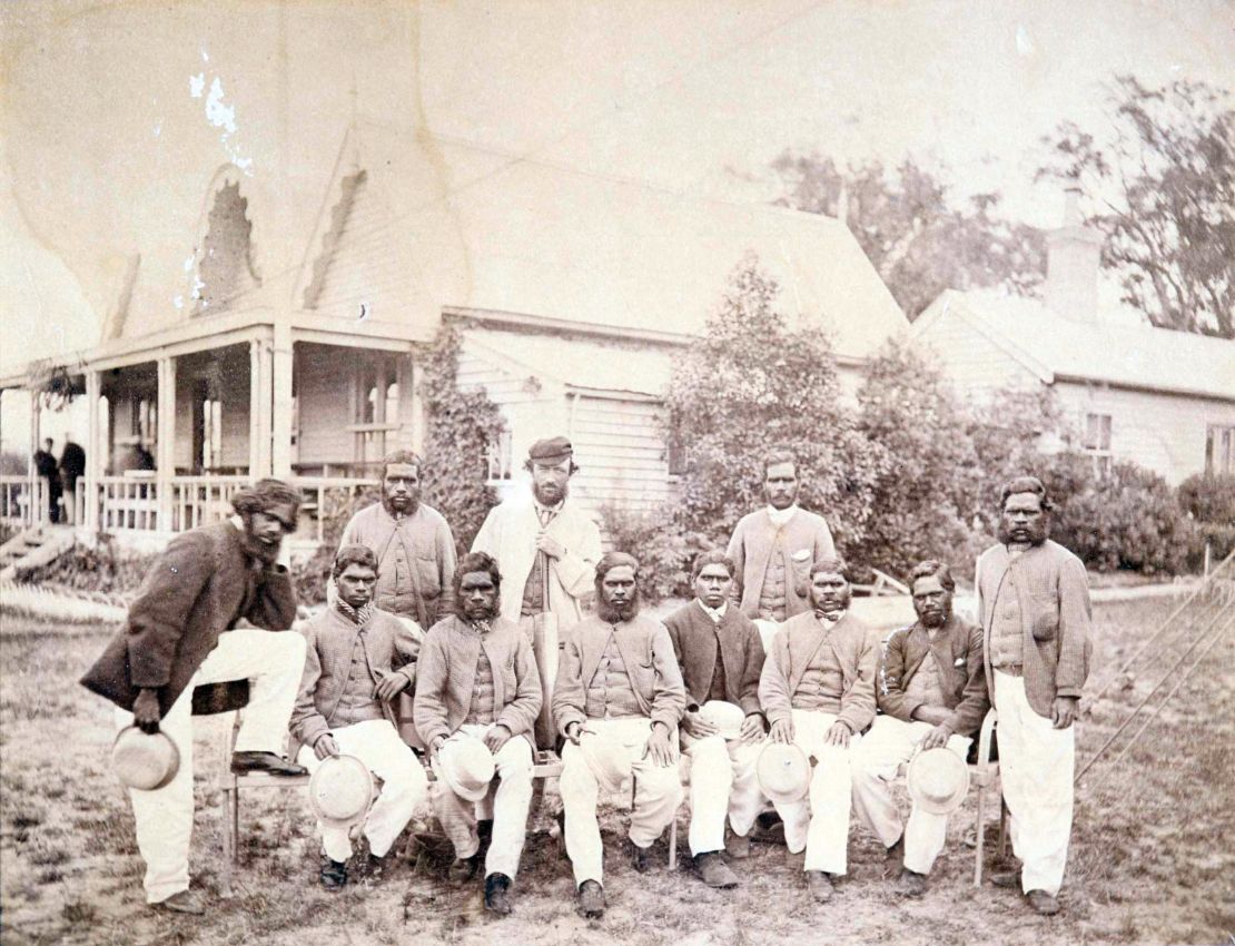 A photo of the all-Aboriginal cricket team at the Melbourne Cricket Ground in 1866, with coach Tom Wills at the back in the center and Johnny Mullagh standing to his right. Yanggendyinanyuk is on the far right.