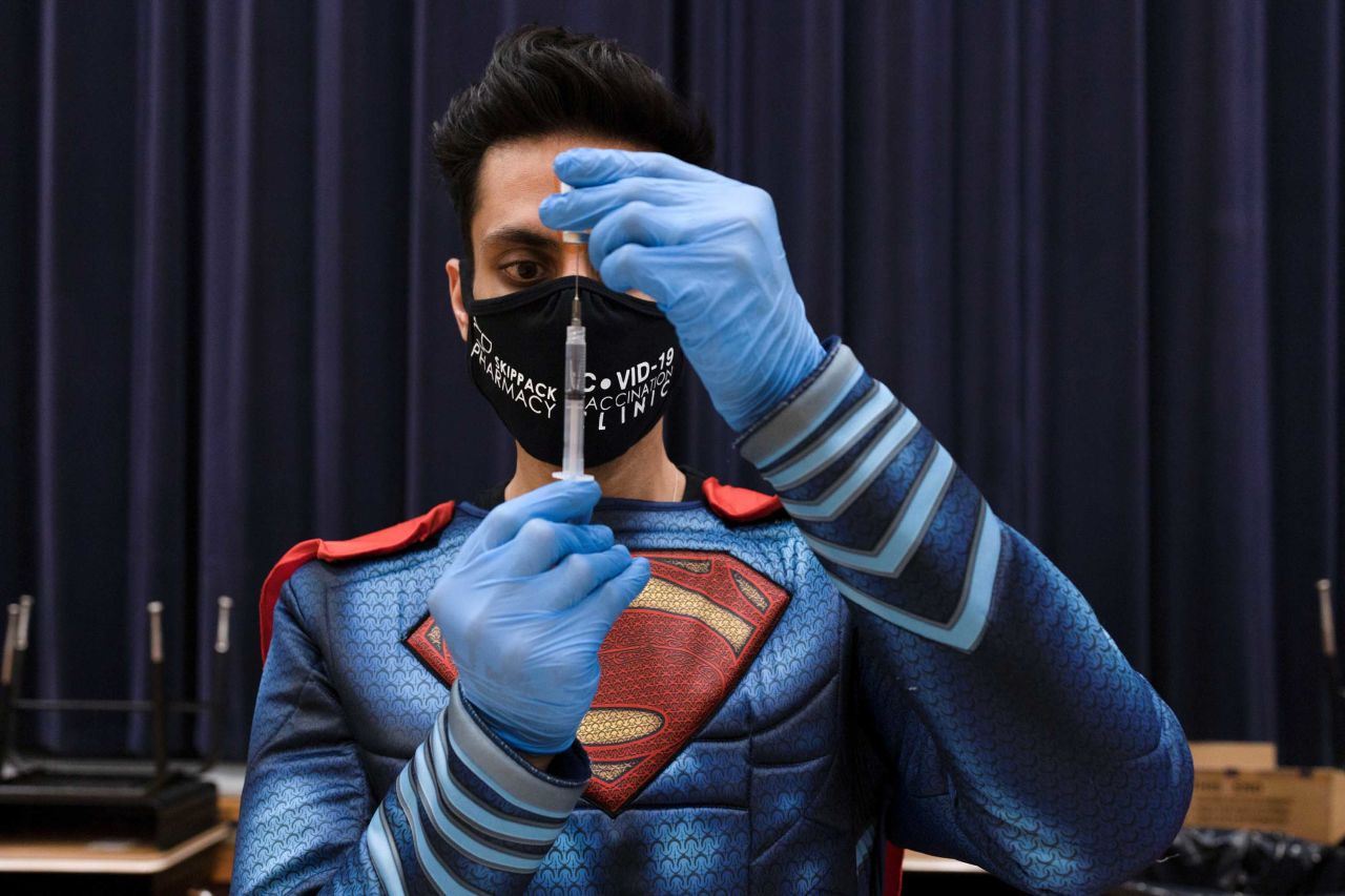 Dr. Mayank Amin, dressed as Superman, prepares a Covid-19 vaccine at a clinic in Collegeville, Pennsylvania, on March 7. <a href="index.php?page=&url=https%3A%2F%2Fwww.reuters.com%2Farticle%2Fus-health-coronavirus-usa-pharmacy%2Fhow-one-small-pennsylvania-pharmacy-is-vaccinating-thousands-idUSKBN2B21CS" target="_blank" target="_blank">Amin has been on a mission</a> to vaccinate thousands of people in his rural community.