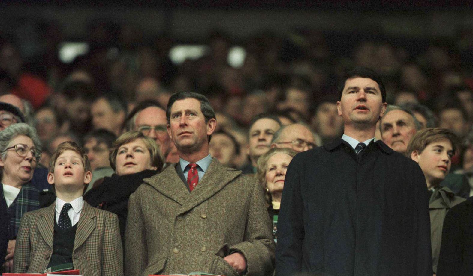 Prince Charles and Prince Harry, at left, stand for anthems as Prince William, right, looks around during the Five Nations rugby championship in 1996.