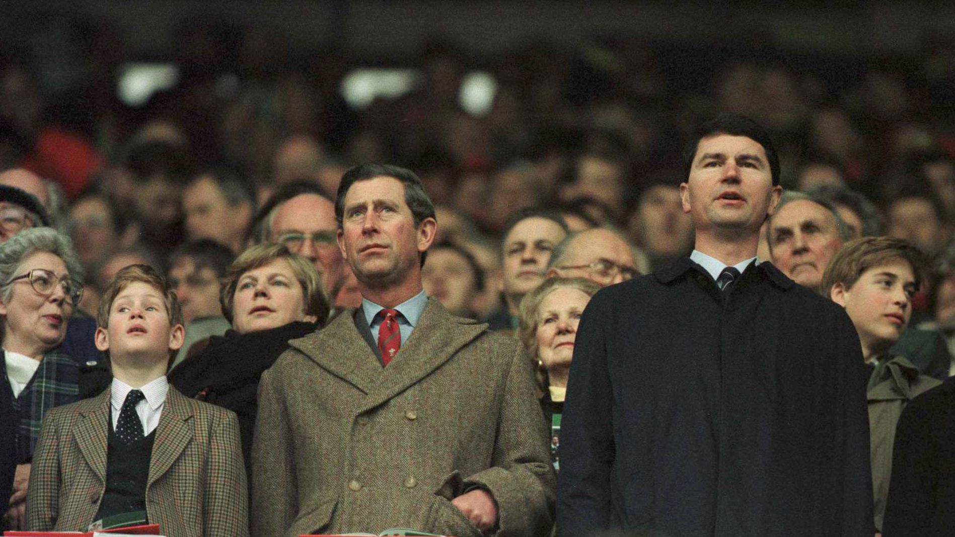 Prince Charles and Prince Harry, at left, stand for anthems as Prince William, right, looks around during the Five Nations rugby championship in 1996.